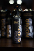 Sea salt spray bottle labeled 'Groom' with a blurred background