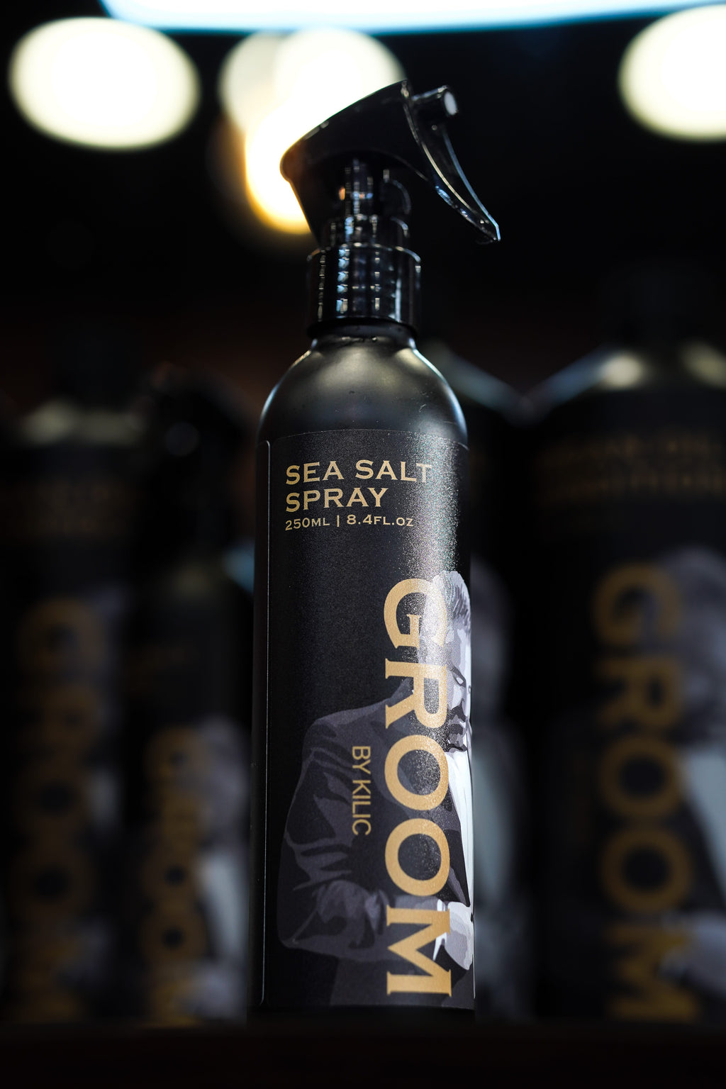 Sea salt spray bottle with 'Groom' branding on a dark background