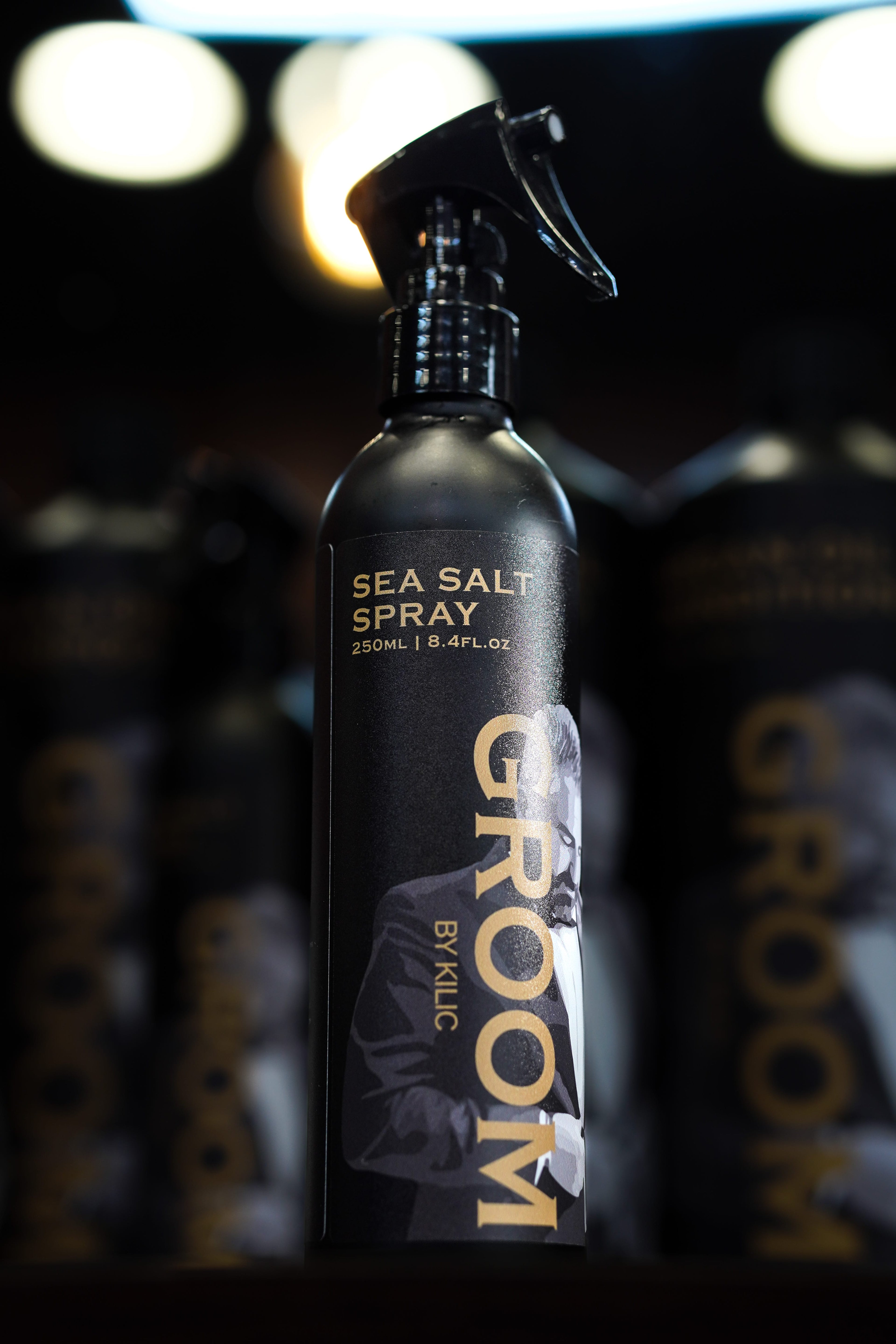 Sea salt spray bottle with 'Groom' branding on a dark background